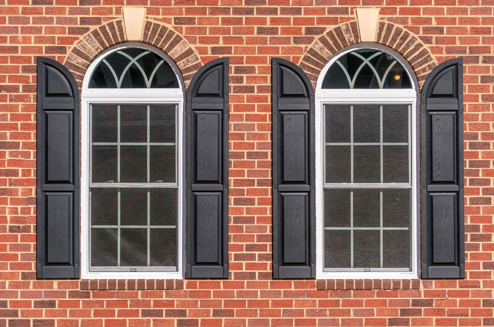 Windows with black shutters on a brick home typical of real estate in Shadeland, Lexington